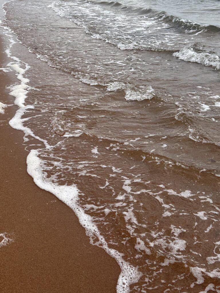 The gentle waves hitting the sand