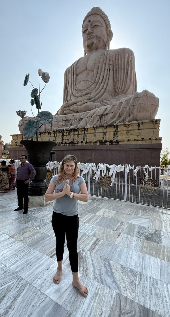 Lisa Cooper in front of a Buddha statue