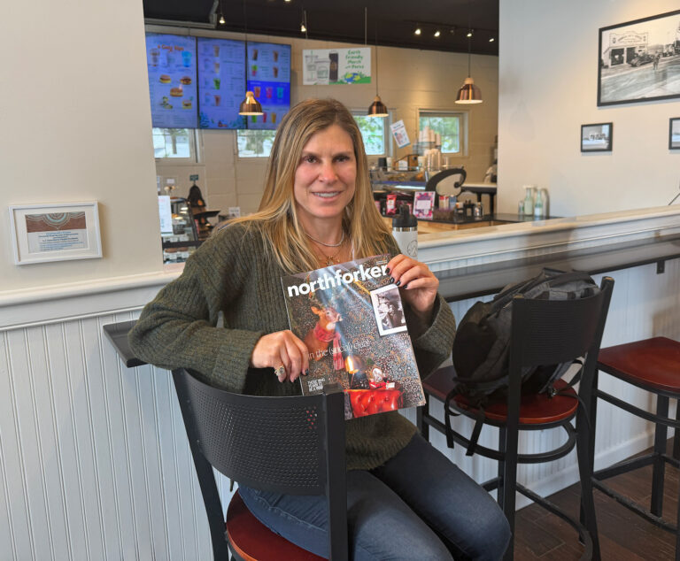 Lisa Cooper of Harmonious Healing with a copy of northforker magazine